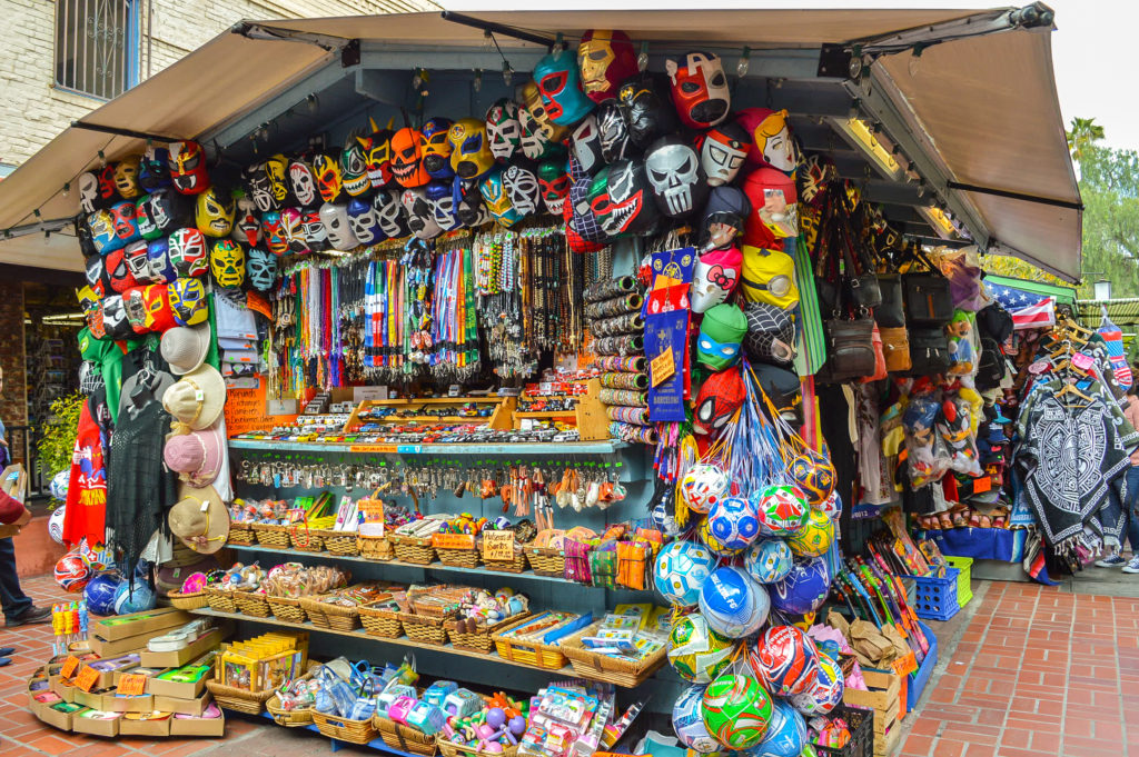 Mexican vendor with bright colored lucha libre masks and other authentic Mexican merchandise