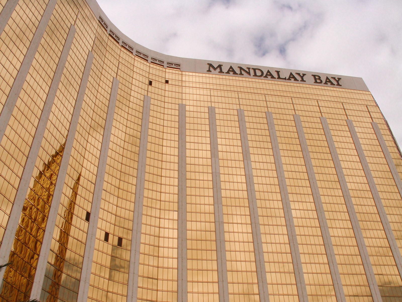 large golden reflective hotel with cloudy skies