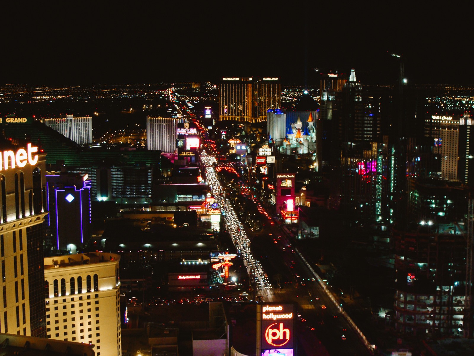 Las Vegas main street at night illuminated by hotels, neon signs, and cars