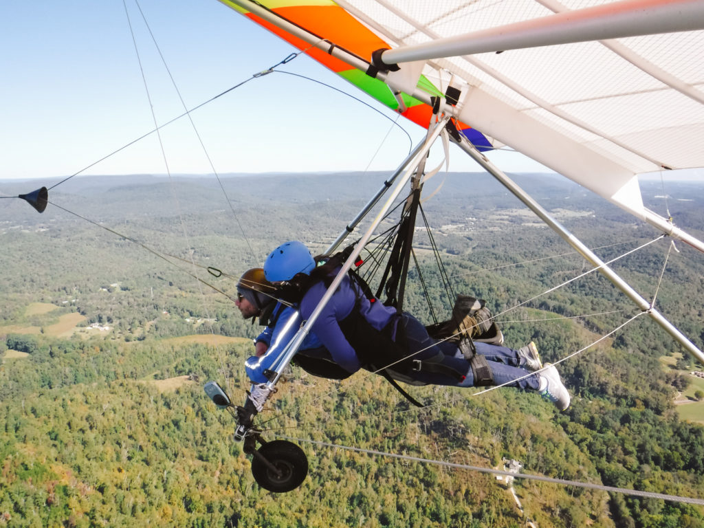 girl hang gliding with an instructor in the green mountains of Georgia USA