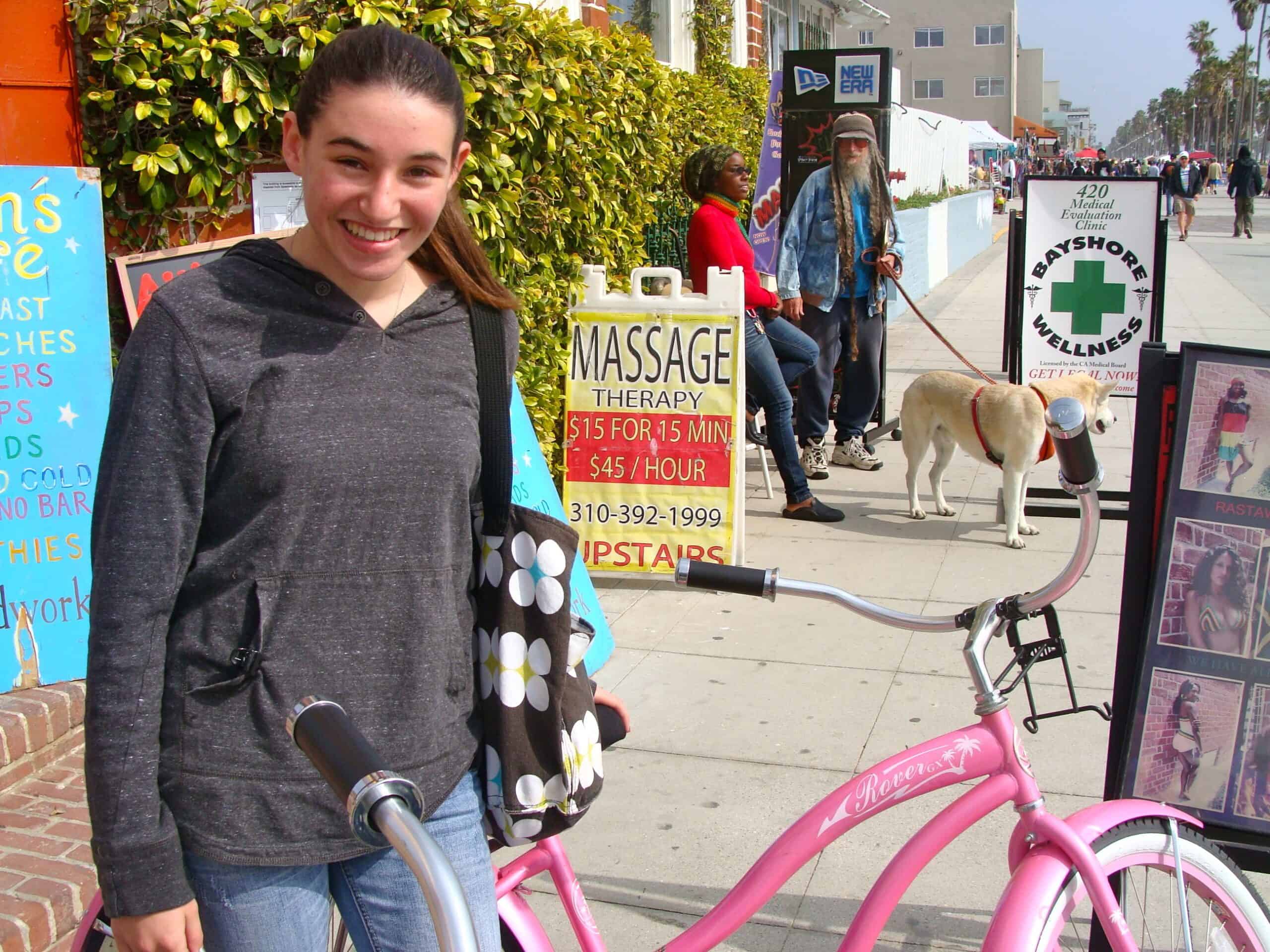 girl about to ride a pink bike
