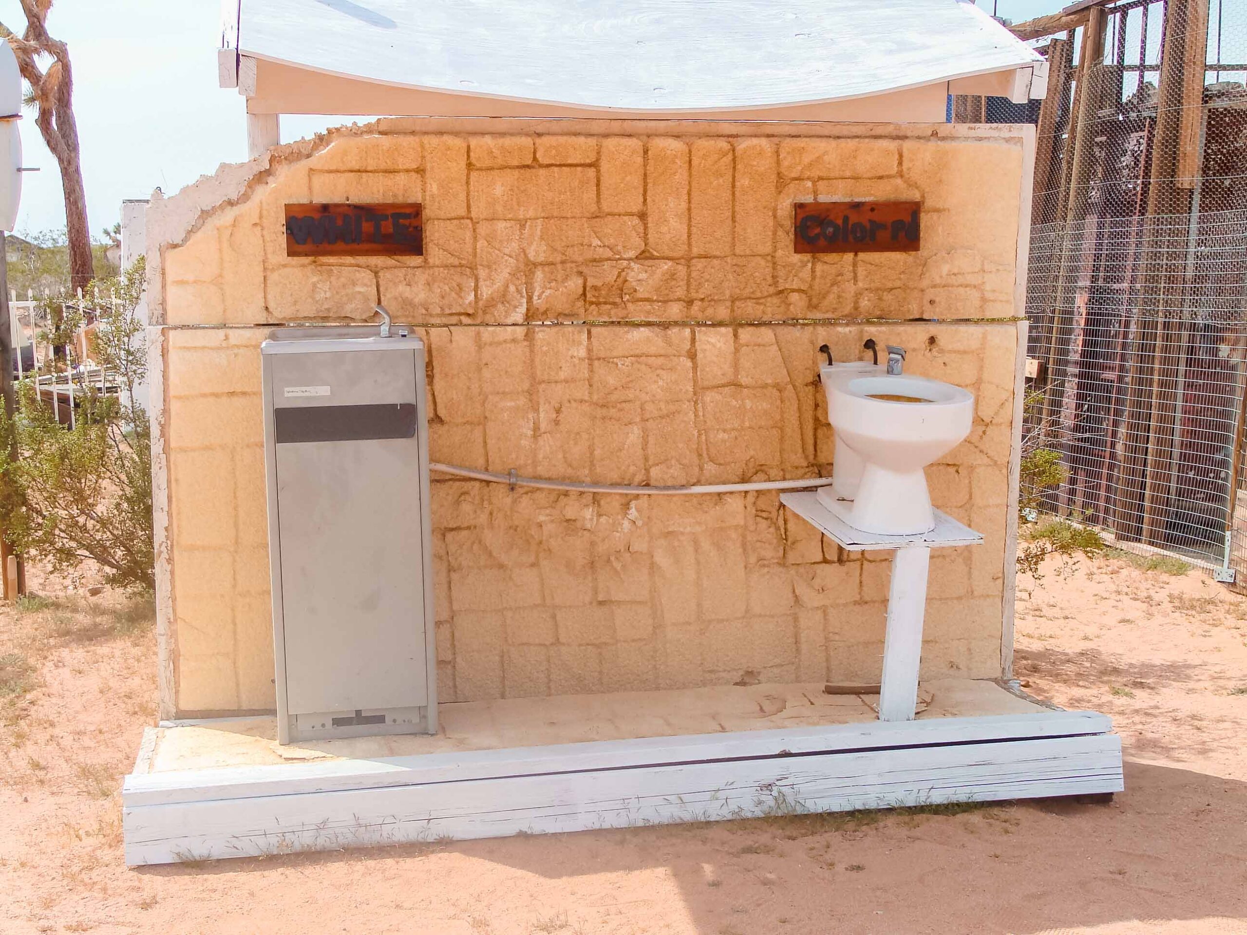 sculpture showing two drinking fountains, one is a normal fountain for "whites" while the other is a toilet for "colored" a political, historical, and cultural statement