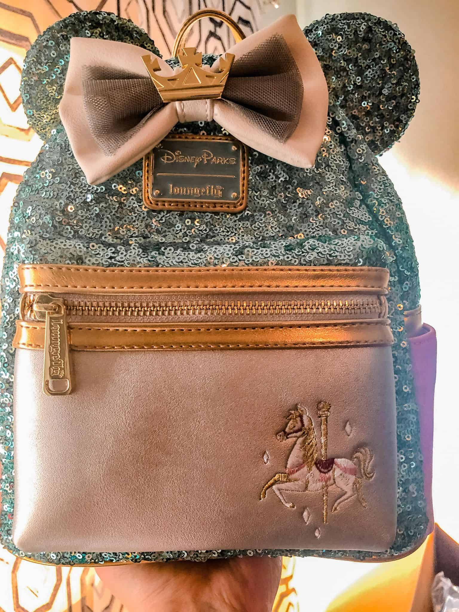 turquoise sequin Loungefly backpack with carousel horse, bow, and crown on the bow with a silver pocket