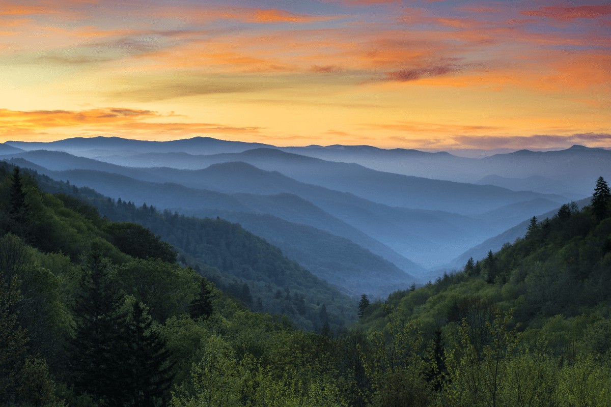 blue ridge mountains in Tennessee showing layers of mountains that stretch into the far distance during sunset with an orange and pink sky