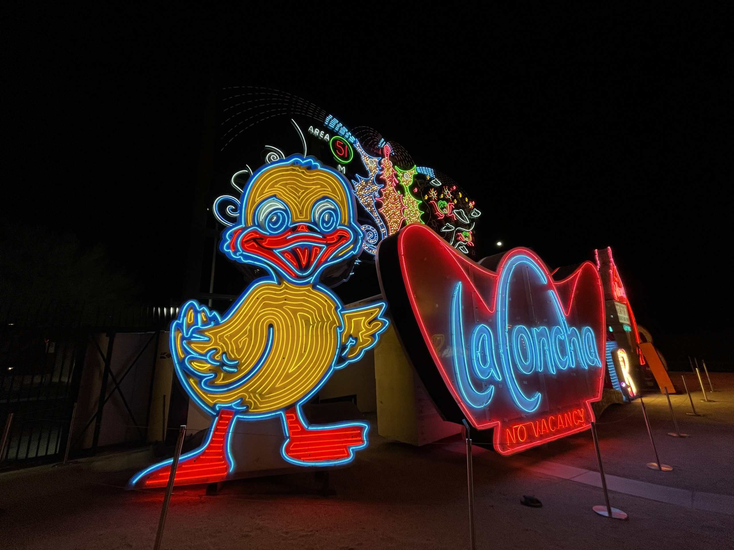 Old Vegas neon signs lit up at night in a neon boneyard museum including neon of a duck and La Concha sign