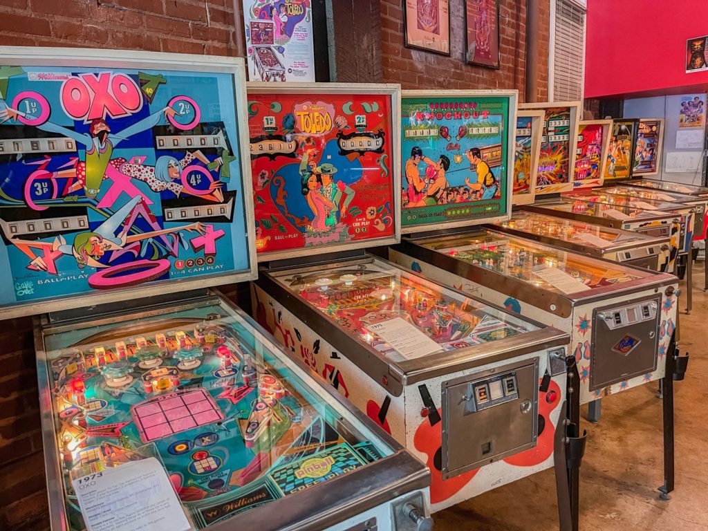 a row of lined up pinball machines from the 1930s and beyond