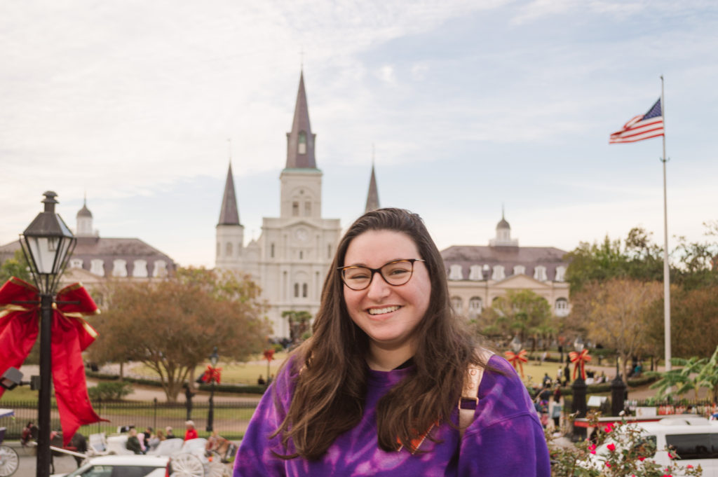 woman laughing at the camera with Jackson Square New Orleans in the background