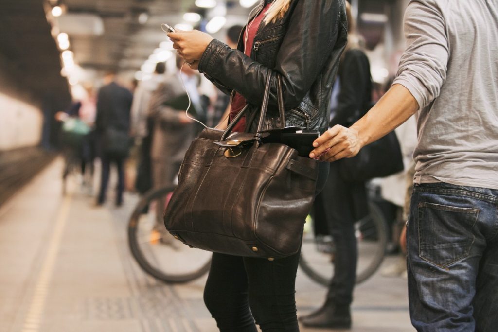 man pickpocketing a woman's purse