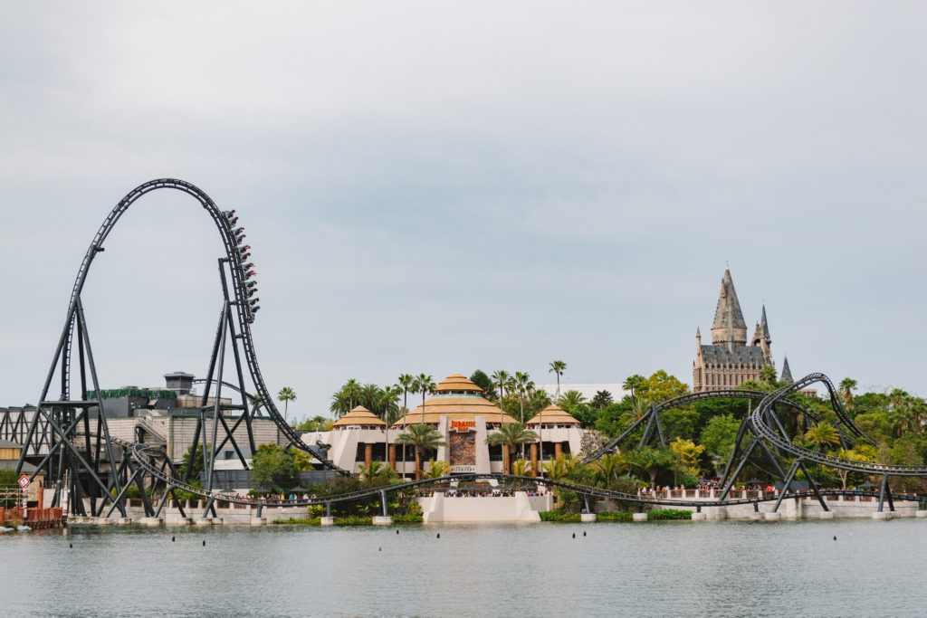 view across the lake of Jurassic Park discovery center, VeliciCoaster, and Hogwarts Castle on a cloudy day