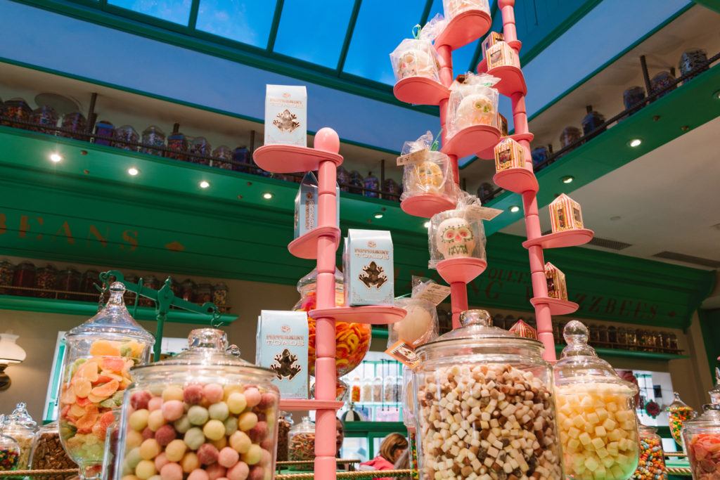 candy stacked on pink displays inside a green candy shop
