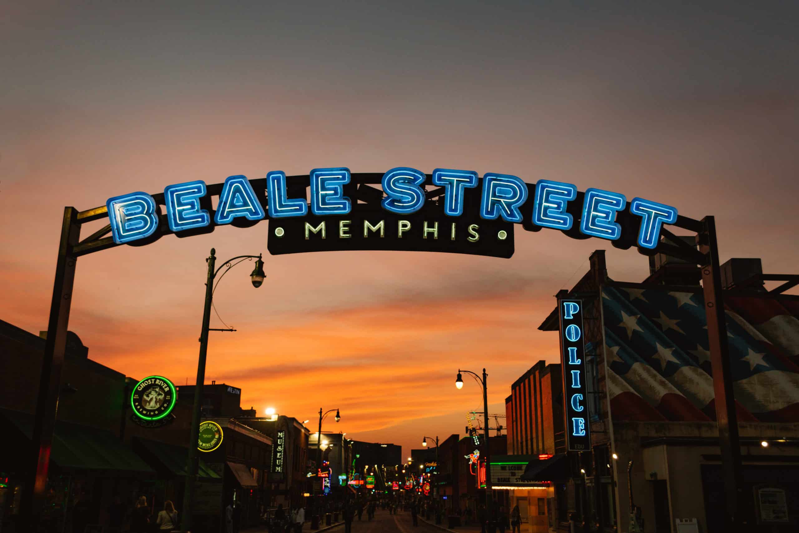 Beale Street sign during sunset with neon signs of local businesses in the distance