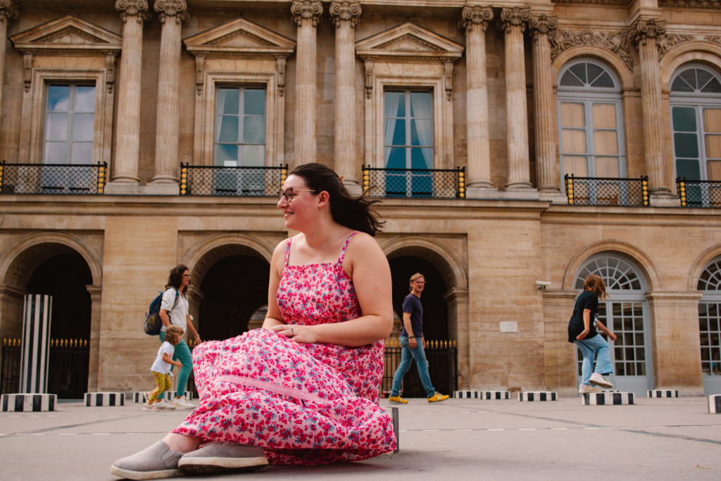 woman in France sitting on a short column