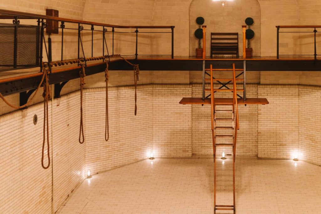 old drained indoor pool with wooden ladder, and ropes used for floating.