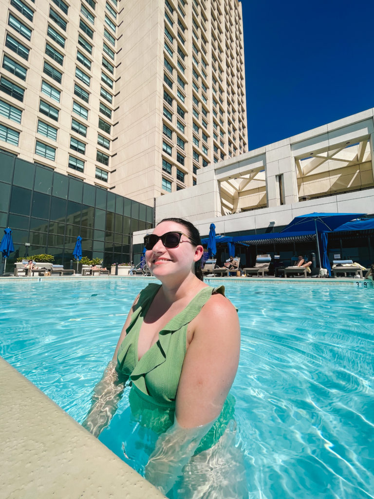 woman in green bathing suit in a hotel swimming pool
