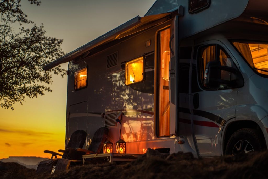 RV parked at sunset with side open.