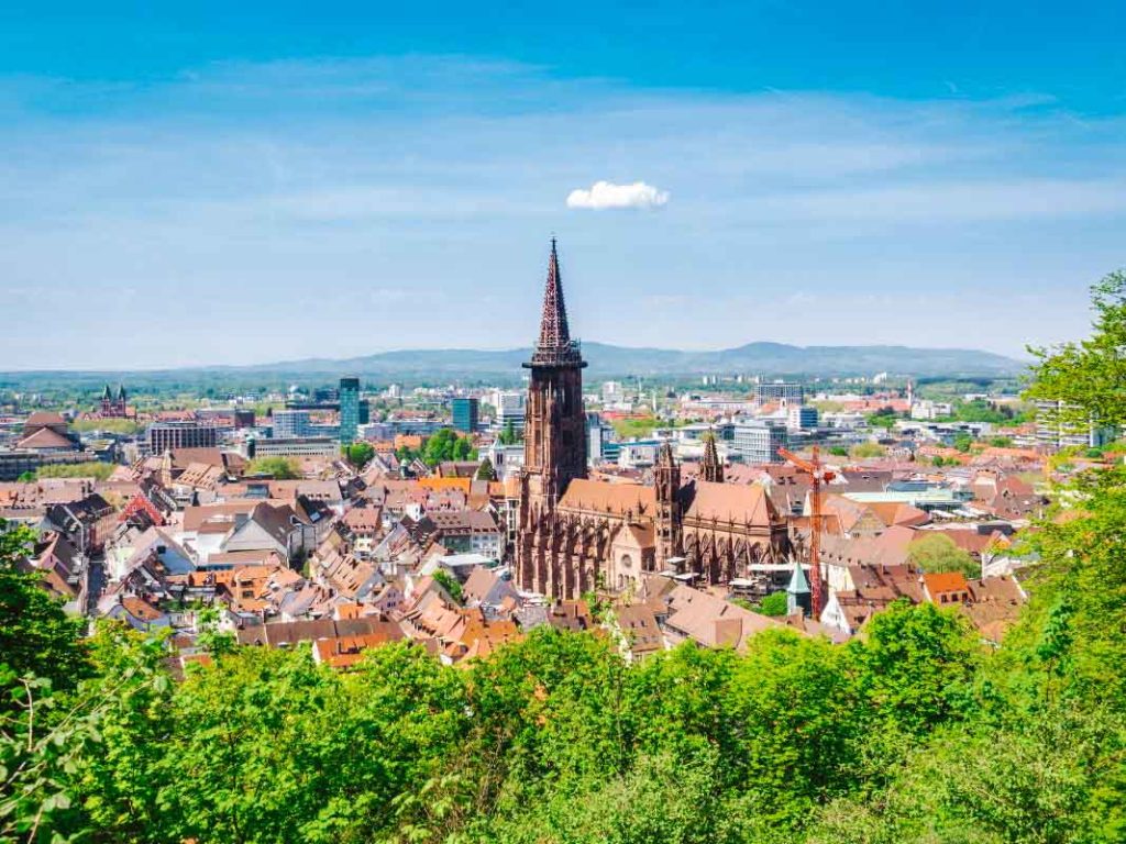 View of Freiburg, Germany from above on a hill with a cathedral and orange topped roofs surrounding
