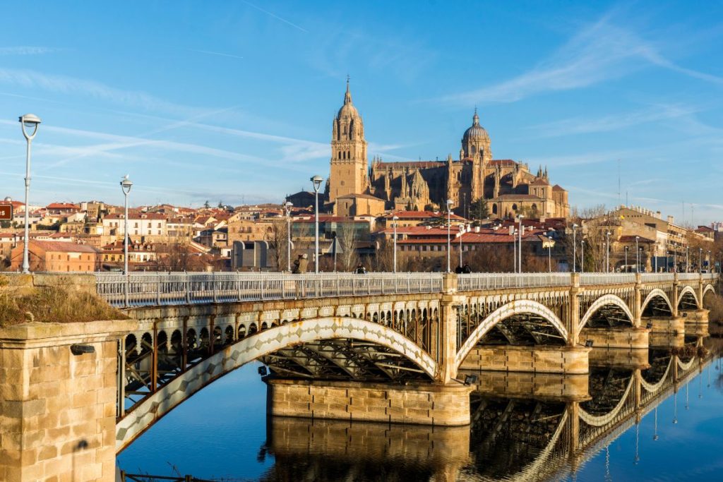City of Salamanca, Spain with a bridge over a river and cathedral in the background