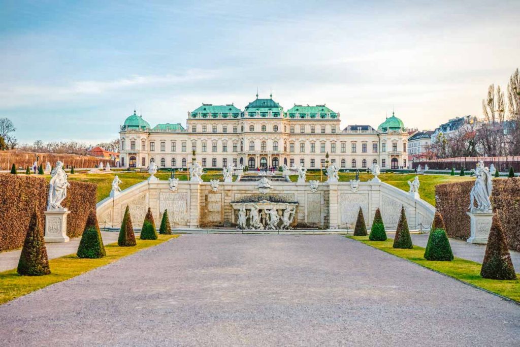 Vienna Austria palace during a sunny day with green roofs and symmetrical garden in front