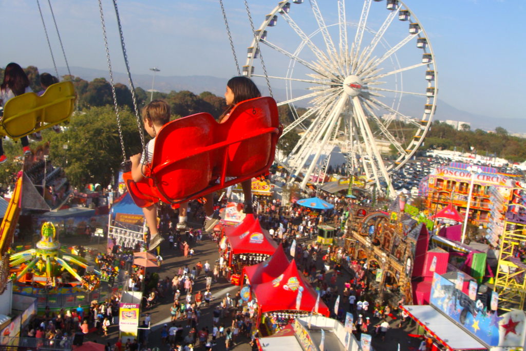 view from on high carnival ride swings overlooking a county fair in Los Angeles