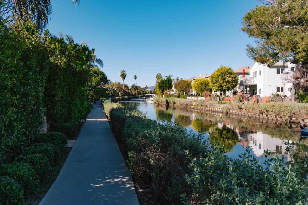 walkway centered with canal to the right with vegetation separating the two