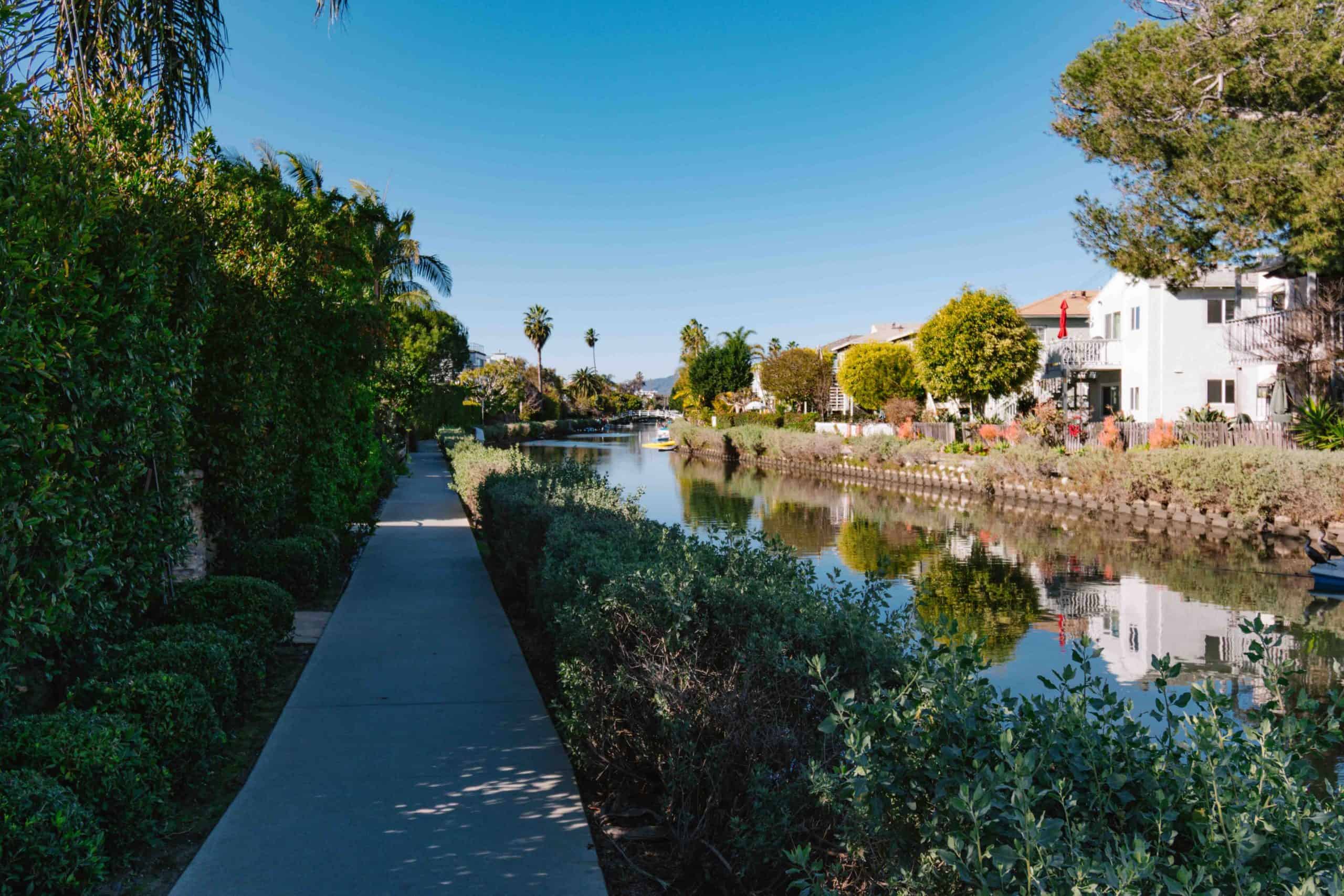 walkway centered with canal to the right with vegetation separating the two