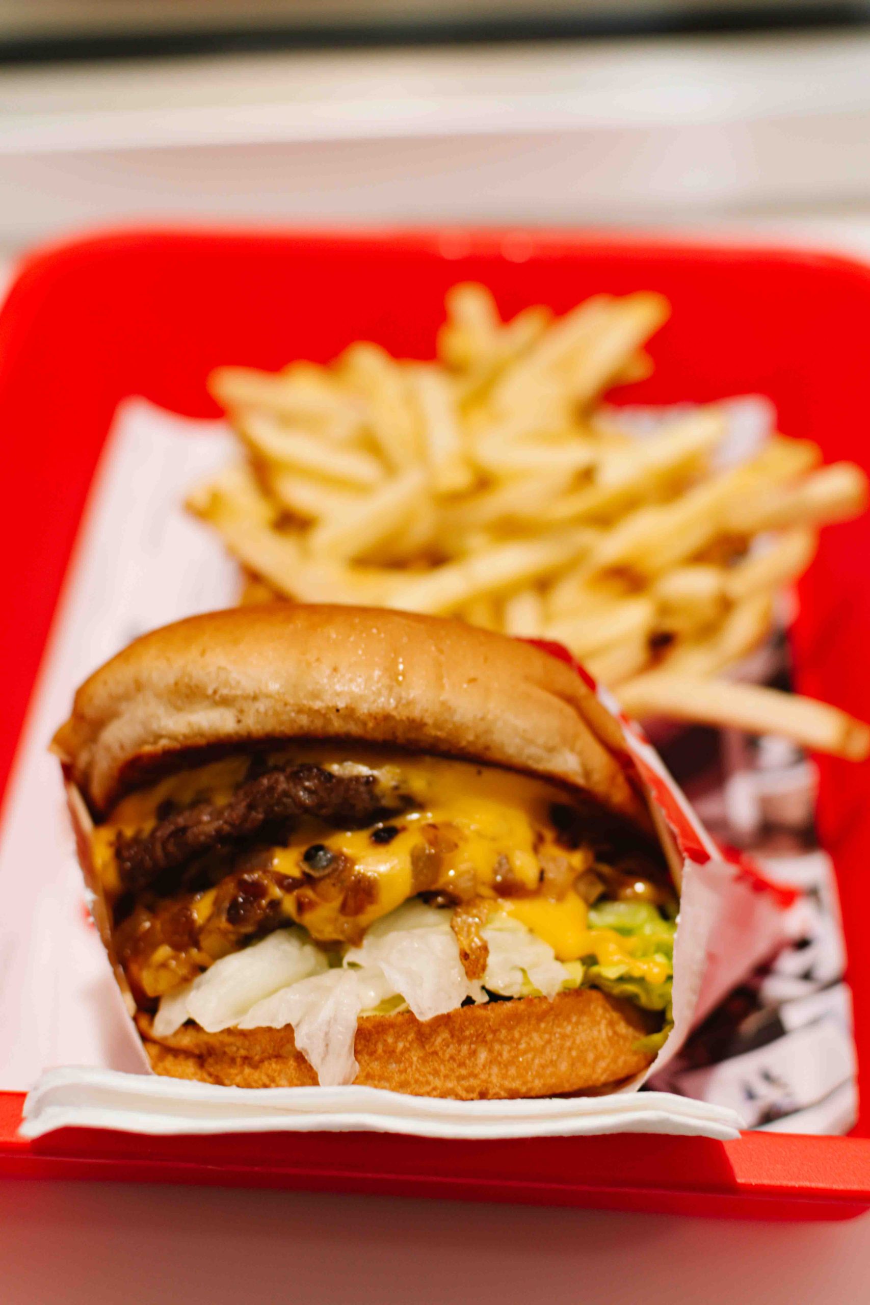 In N Out burger and fries in a red tray.