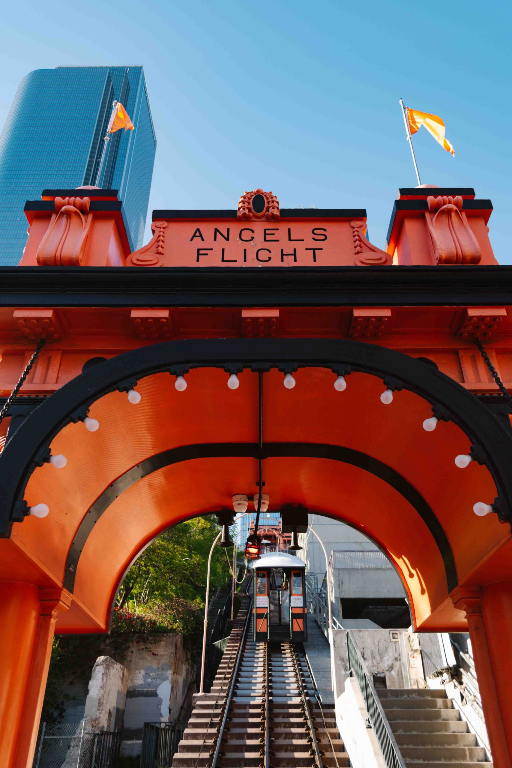 bright orange archway with railway underneath climbing a hill in downtown Los Angeles