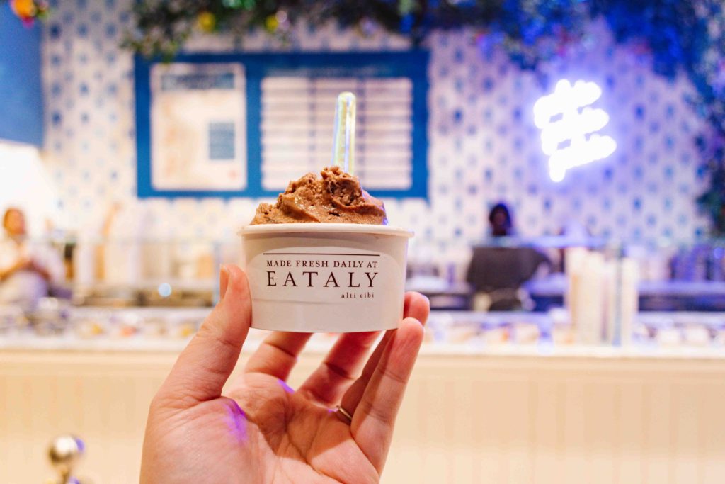 woman's outstretched hand holding chocolate gelato from Eataly