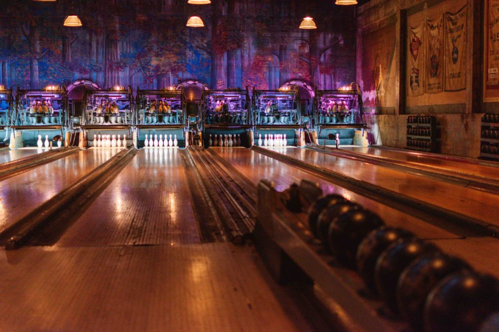 historic wooden bowling alley with forest mural on the back wall