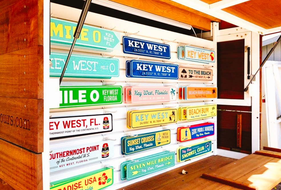 Key West signs for souvenirs hanging on a vendor's wall.