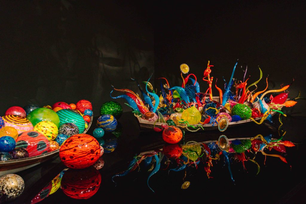 Glass sculptures inside small wooden boats