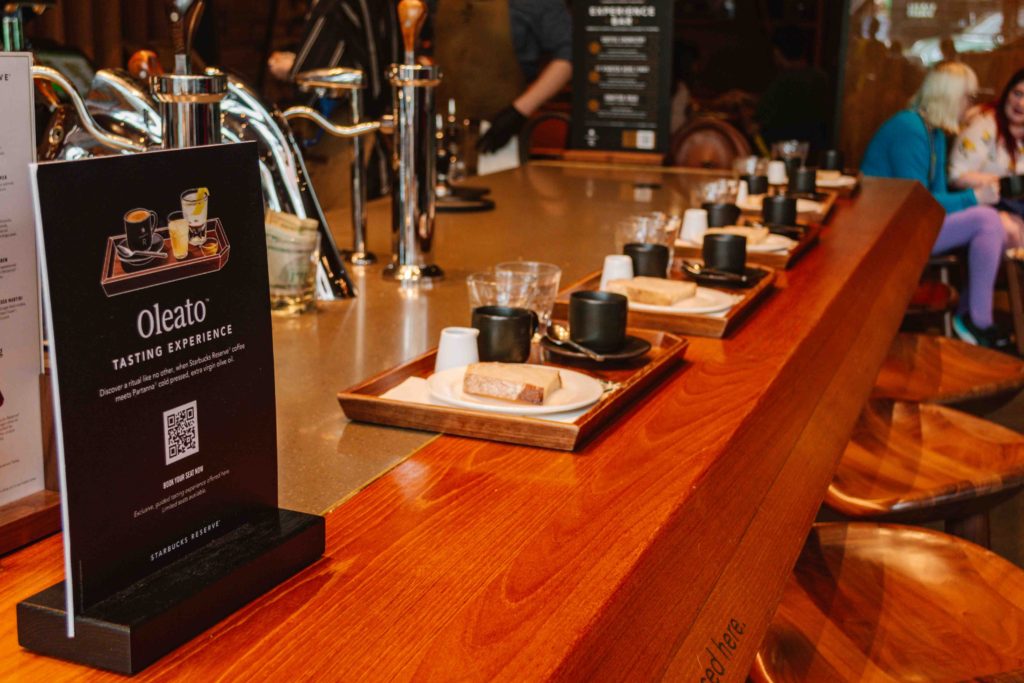 Oleato tasting experience bar with trays of olive oil, bread, and coffee.