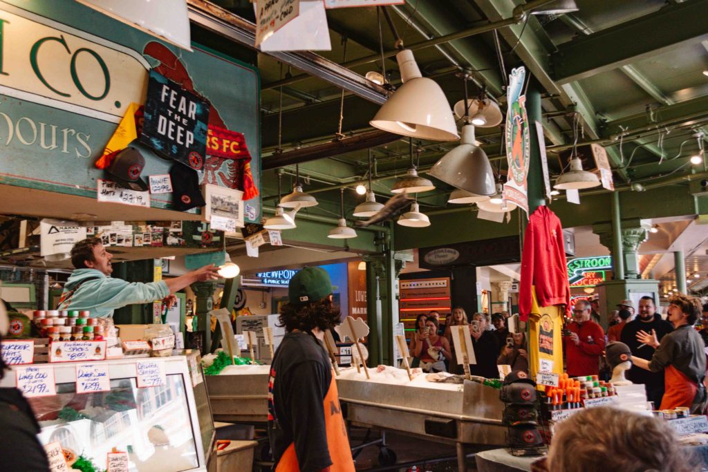 flying fish being thrown by fish sellers in Pike Place Market, Seattle, Washington, USA