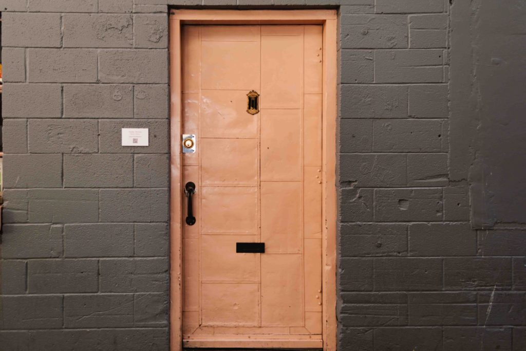 Pink door on a grey wall in Pike Place Market