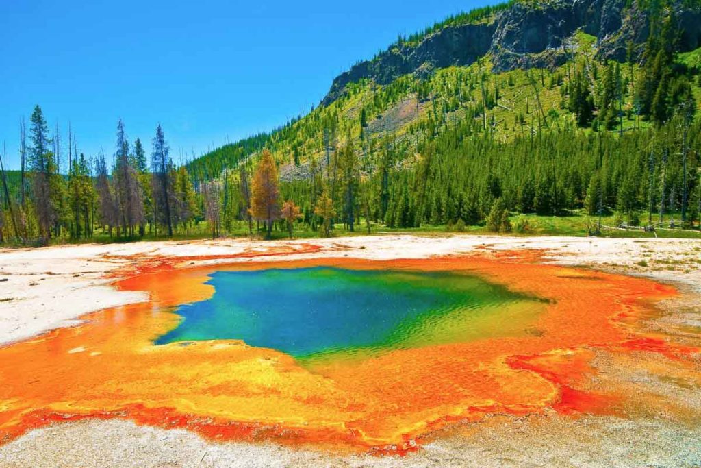 multi-colored geothermal pool in Yellowstone national park in Wyoming in America with orange, yellow, red, green, and blue colors.