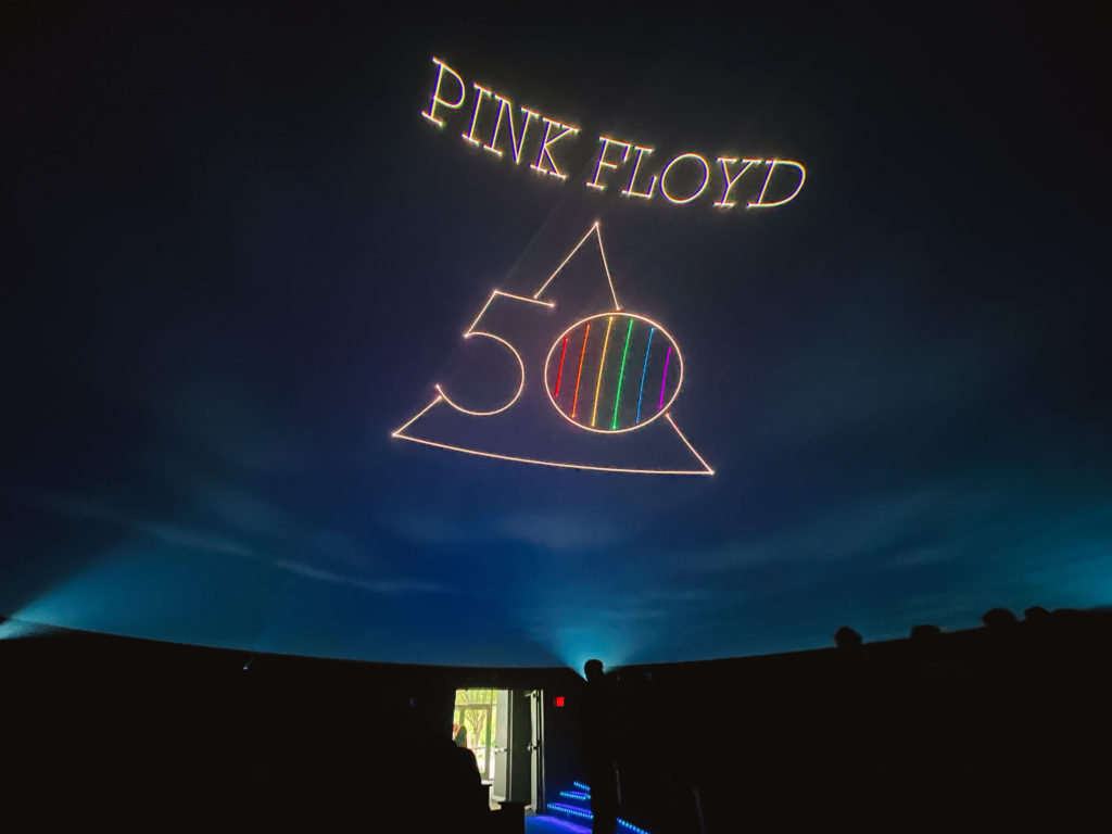 View of laser planetarium Pink Floyd 50 Dark Side of the Moon show with people entering the door across from the way