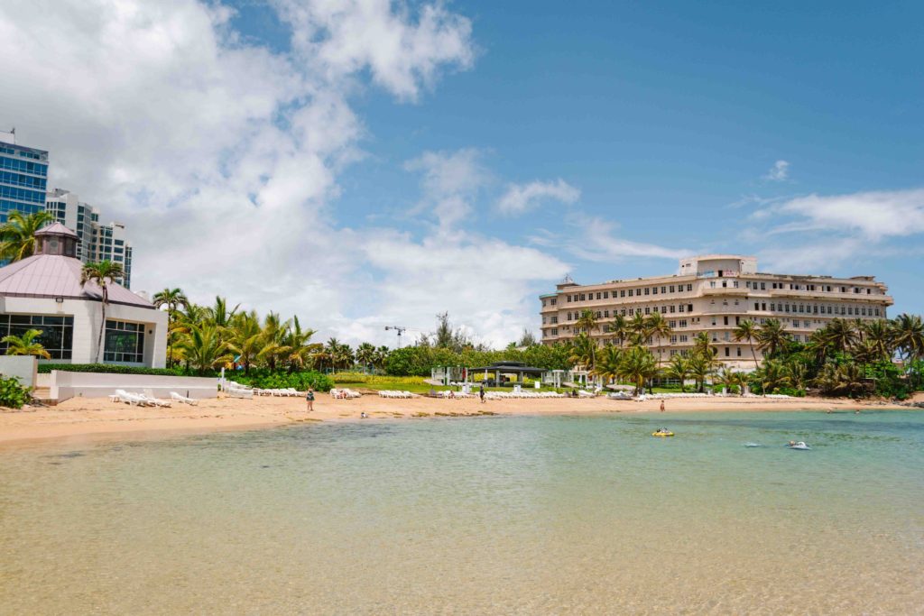 shallow calm beach in San Juan, with hotel in the background to the right