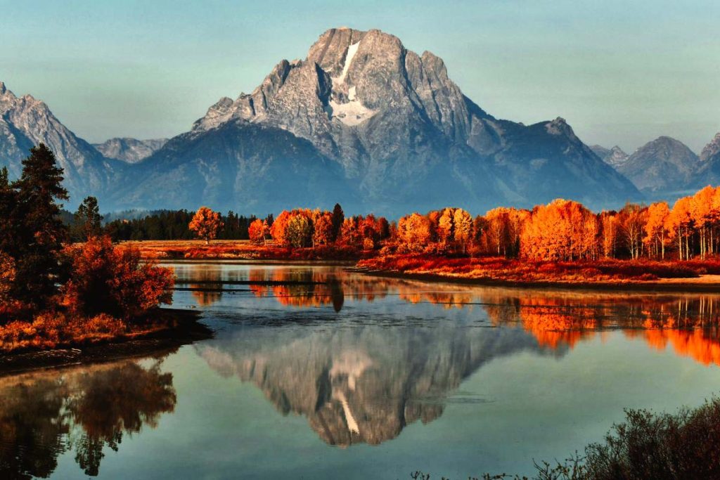 Jackson Hole mountains, trees, and lake with fall foliage in autumn.