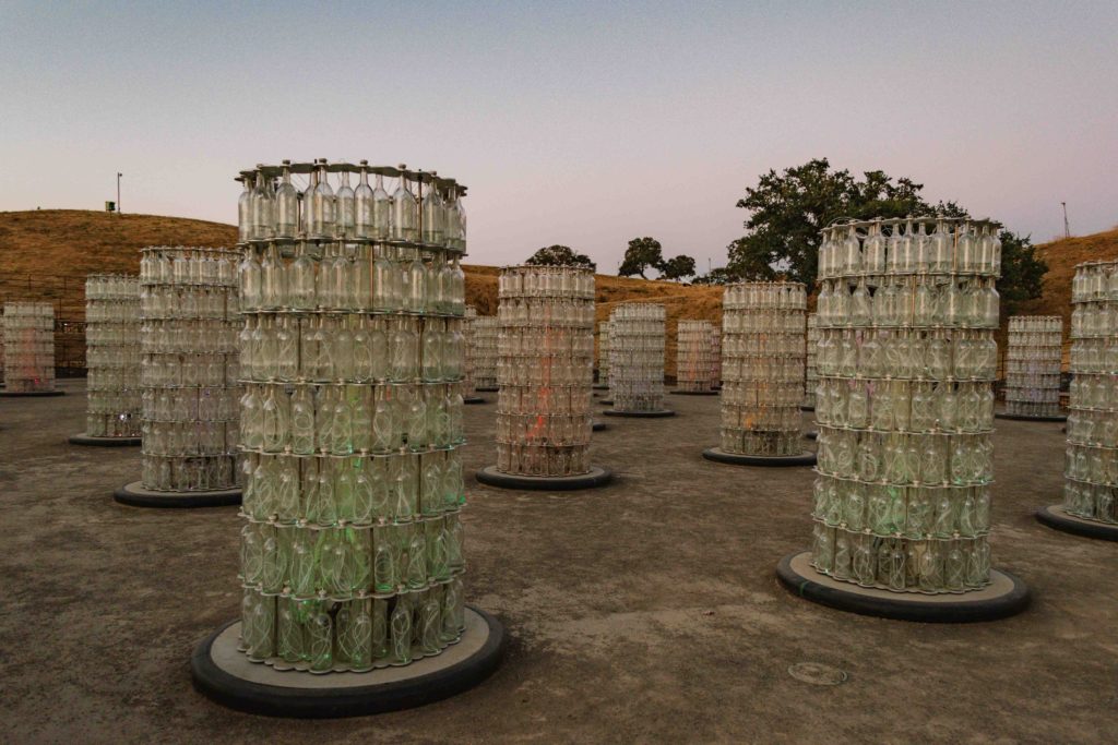 Light towers made of wine bottles lit up during sunset