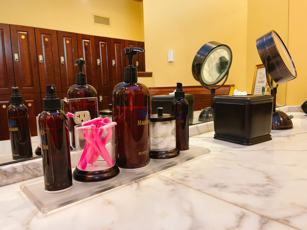 counter of women's amenities like razors, shaving cream, lotion, cotton balls, and mirrors.