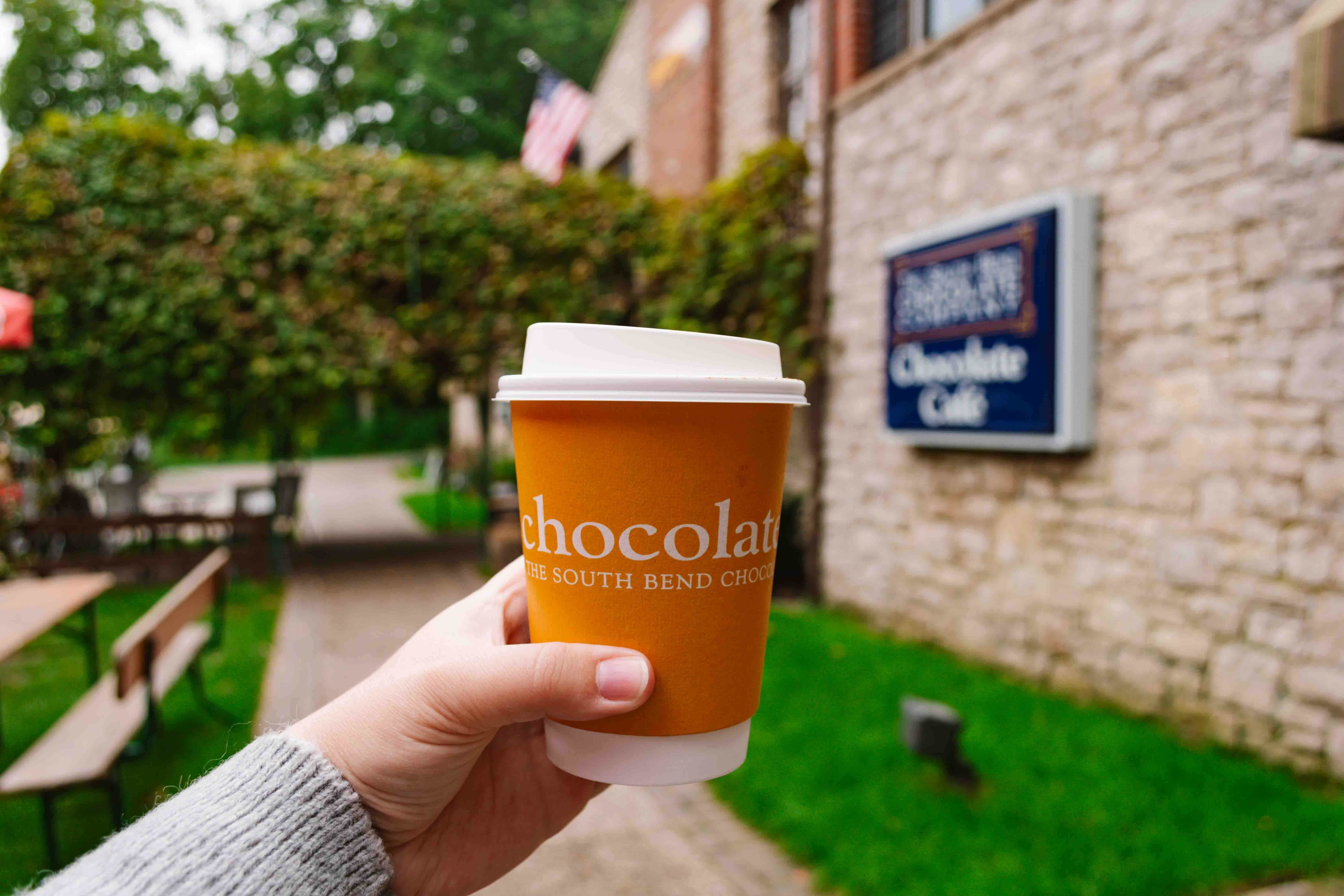 South Bass Island, Ohio Chocolate Cafe where woman is holding an orange coffee cup with hand outstretched from camera