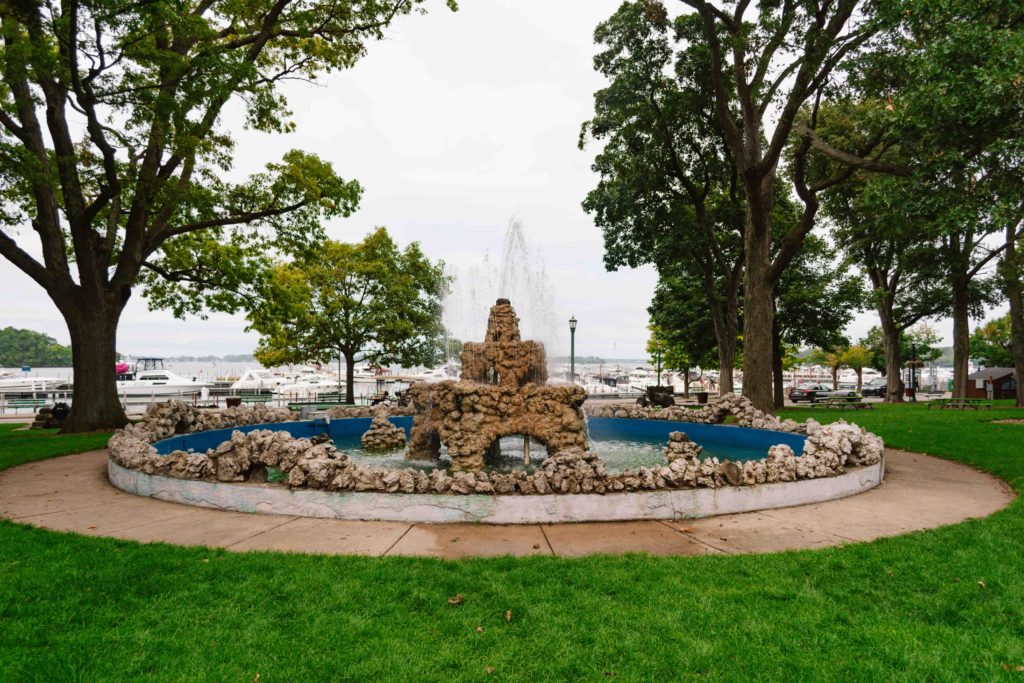 View of a fountain in a park that looks like a sandcastle with the Lake Erie Bay behind