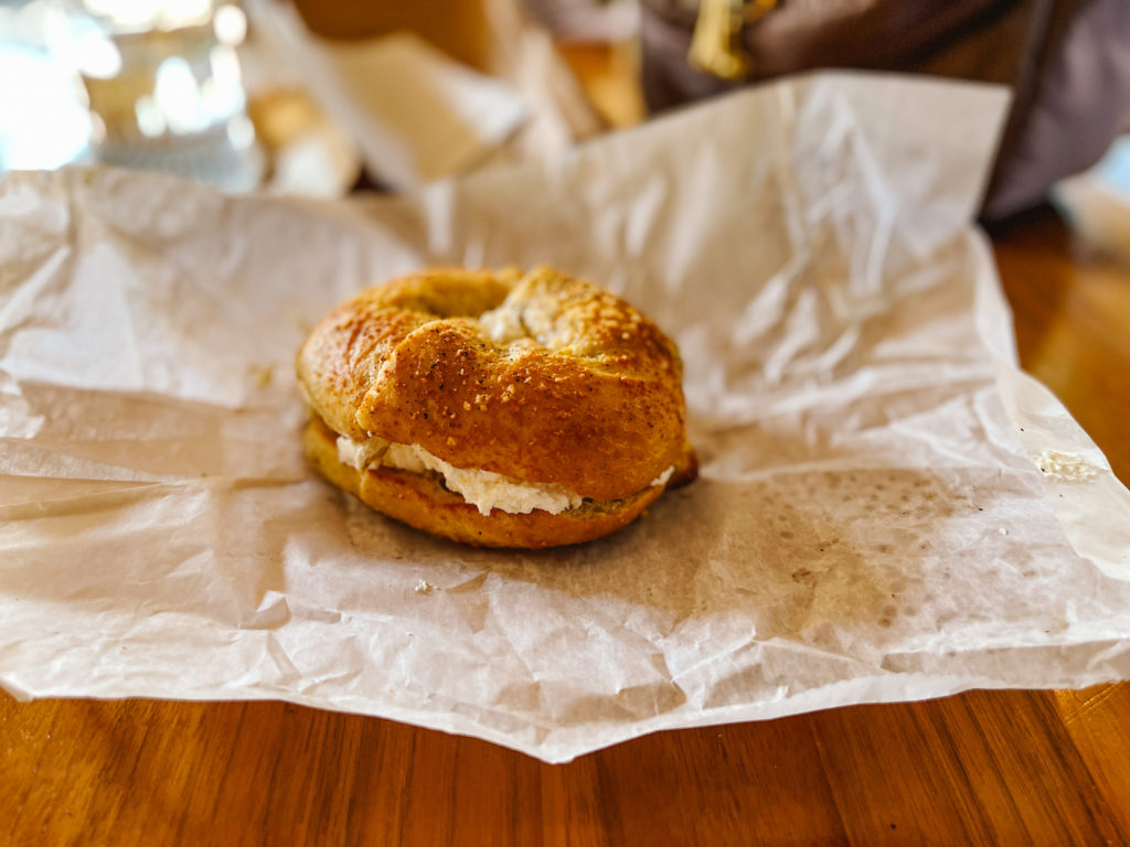 Cacio e pepe bagel with a lot of cream cheese sandwiched in the middle