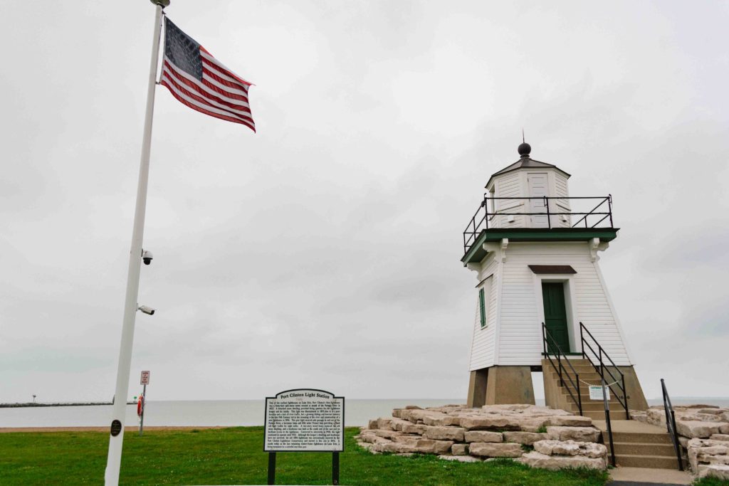 View of Port Clinton Lighthouse in Ohio with American flag waving to the left