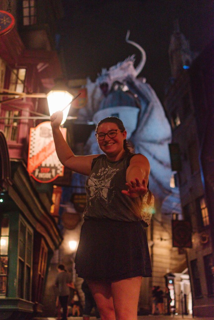Diagon Alley at night woman holding an interactive wand