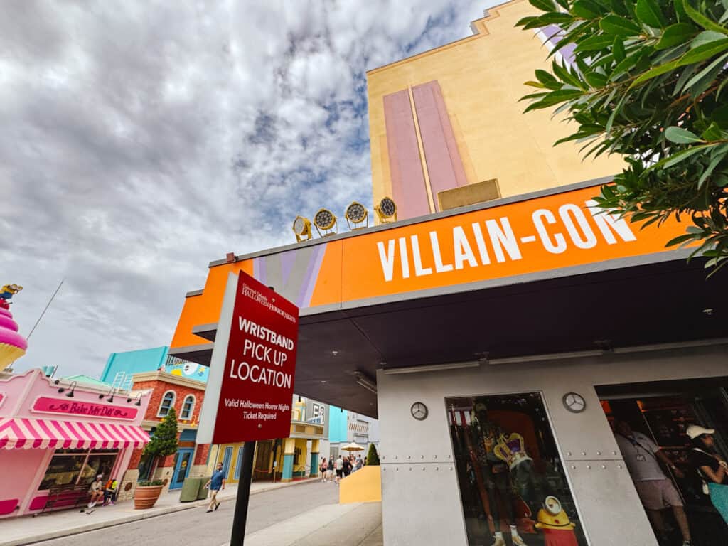 Outside of Villain-Con at Universal Studios where there's a temporary sign that says Wristband Pick Up Location for Halloween Horror Nights Scream Early