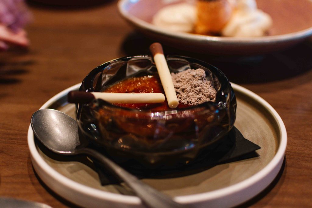 Creme brulee plated in an ashtray with chocolate "cigarettes" and hazelnut powder "ash" served at Brazen, the restaurant at the Mount Royal Hotel in Banff national park