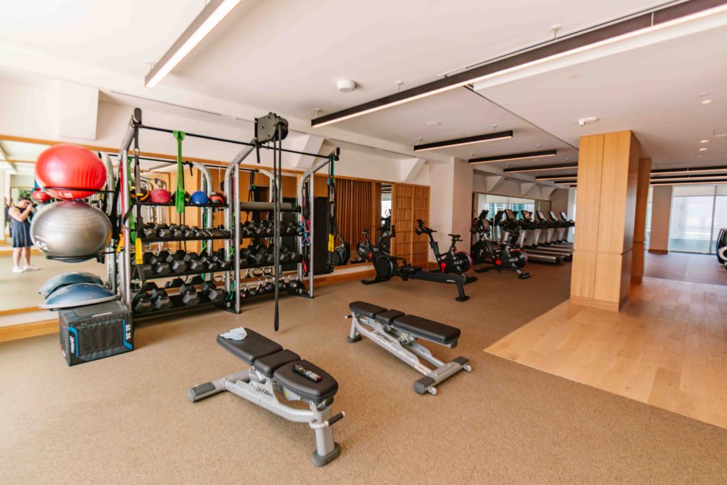 Nice hotel gym with racks of weights, exercise balls, cardio machines, and more in an open space