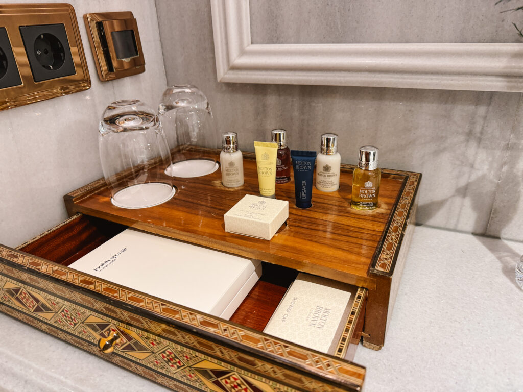 Bathroom amenities including shampoo, conditioner, lotion, loofahs, shower caps, and more in a luxury hotel bathroom in Turkey