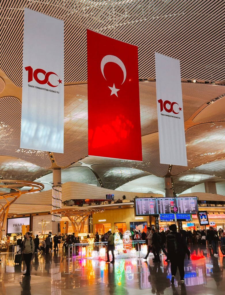 Inside of IST airport during the winter holidays with Turkey flags hanging from the tall ceilings.